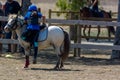 Little Girl that gets back in th saddle of a Pony during Pony competition at the Equestrian School