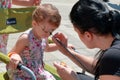 Little girl getting her face painted like a butterfly Royalty Free Stock Photo