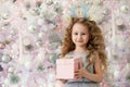 Little girl with gift, present near white Christmas tree Royalty Free Stock Photo