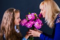 Little girl gives mom flowers and wishes her with mothers day