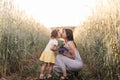 A little girl gives a bouquet of lupines to her mother on the field in the summer. Concept of love and happy family Royalty Free Stock Photo