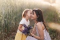 A little girl gives a bouquet of lupines to her mother on the field in the summer. Concept of love and happy family Royalty Free Stock Photo