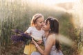 A little girl gives a bouquet of lupines to her mother on the field in the summer. Concept of love and happy family Royalty Free Stock Photo