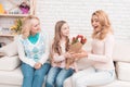 A little girl gives a bouquet of tulips to her mom and grandmother. Royalty Free Stock Photo