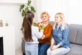 A little girl gives a bouquet of tulips to her mom and grandmother. They celebrate Mother& x27;s Day. They have a traditional Royalty Free Stock Photo