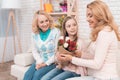 A little girl gives a bouquet of tulips to her mom and grandmother. Royalty Free Stock Photo