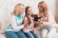 A little girl gives a bouquet of tulips to her mom and grandmother. Royalty Free Stock Photo