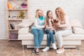 A little girl gives a bouquet of tulips to her mom and grandmother. Royalty Free Stock Photo