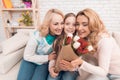 A little girl gives a bouquet of tulips to her mom and grandmother. Royalty Free Stock Photo