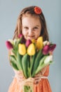 Little girl giving colorful flowers, smiling sincerely Royalty Free Stock Photo