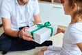 Little girl is giving her handsome father a gift box on Father`s day Royalty Free Stock Photo