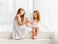 Little girl giving her teddy bear toy to older sister Royalty Free Stock Photo