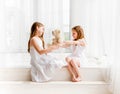 Little girl giving her teddy bear toy to older sister Royalty Free Stock Photo