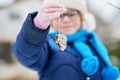 Little girl with glasses feeds birds on winter. Happy smiling preschool child hanging selfmade bird seed heart on tree Royalty Free Stock Photo