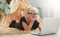 Little girl with glasses having fun with laptop on the floor in her room Royalty Free Stock Photo