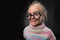 Little girl in glasses makes faces