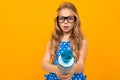 A little girl with glasses with a microphone is interviewed, the picture is isolated on yellow background