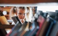 Little girl in glasses searching for a book in the library. Conception of education