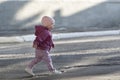 Little girl goes on the empty street. Child abandoned on street. Toddler walks alone