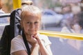 A little girl is going by bus. Schoolgirl sitting in school bus and ready for her first ride