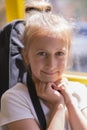 A little girl is going by bus. Schoolgirl sitting in school bus and ready for her first ride. vertical photo