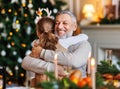Little girl granddaughter embracing happy smiling grandfather during Christmas dinner at home Royalty Free Stock Photo