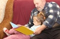 The little girl with the grandfather read the book Royalty Free Stock Photo