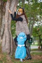 Little girl on grandma costume playing with her mom. Real family having fun while using costumes of the Little red riding hood Royalty Free Stock Photo