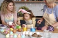 Little girl with grandma and mother helping during Easter