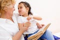 Little girl with grandma reading interestng book