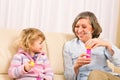 Little girl with grandmother play bubble blower Royalty Free Stock Photo