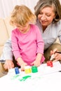 Little girl with grandmother play paint handprints