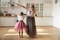 Little girl with grandmother wearing princess skirts showing dab gesture