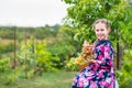 Little girl with grapes in the garden.