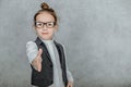 Little girl on a gray background. Dressed up as a business woman with black glasses. Isolated on a white background Royalty Free Stock Photo