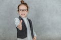 Little girl on a gray background. Dressed up as a business woman with black glasses. Isolated on a white background Royalty Free Stock Photo