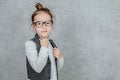Little girl on a gray background. Dressed up as a business woman with black glasses. Isolated on a white background Royalty Free Stock Photo