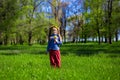 Little girl on a green grass in a wreath of flowers in spring Royalty Free Stock Photo