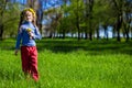 Little girl on a green grass in a wreath of flowers in spring Royalty Free Stock Photo