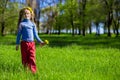 Little girl on a green grass in a wreath of flowers in spring Royalty Free Stock Photo