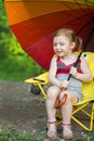 Little girl with a grimy legs sitting on a chair