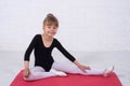 A little girl in a gymnastic swimsuit performing exercises, free space