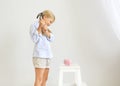 Little girl with hammer by the pink pig piggy bank Royalty Free Stock Photo