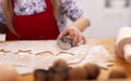 Little girl hand cutting gingerbread cookies from dough