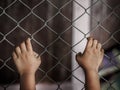 Little girl hand holding on chain link fence for freedom, Human