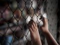 Little girl hand holding on chain link fence for freedom, Human