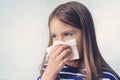 Little girl with handkerchief. A cold girl blows her nose in a white rag on a blue background. Diseases and colds. Rhinitis snot Royalty Free Stock Photo