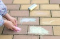 Little girl hands draws on asphalt, paving stones with colorful chalk. Royalty Free Stock Photo