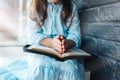 Little girl hands folded in prayer on a Holy Bible in church for faith concept in vintage color tone Royalty Free Stock Photo