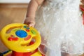 Little girl hands on helm of yellow baby car